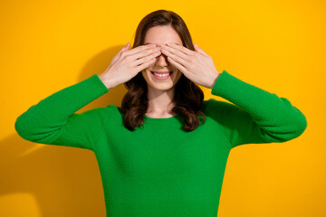 Poster - Photo of cheerful carefree girl wear stylish green clothes two arms cover eyes isolated on yellow color background