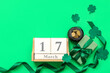 canvas print picture - Pot with golden coins, gift box and calendar on green background. St. Patrick's Day celebration
