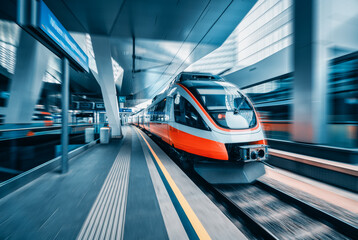 Wall Mural - orange high speed train in motion at modern railway station in vienna. fast intercity passenger trai