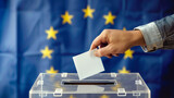 Fototapeta Tęcza - Man throwing his vote into the ballot box. Elections to the European Parliament