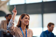© Drazen - Happy businesswoman raising her hand to ask question while attending seminar in conference room