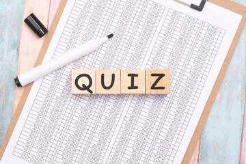 Sticker - QUIZ - inscription on wooden cubes on a white background along with a tabular document. finance and business concept