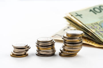 Polish zloty banknotes and coins. Polish currency. Polish zloty coins stacked on each other in different positions. Money saving concept on white background