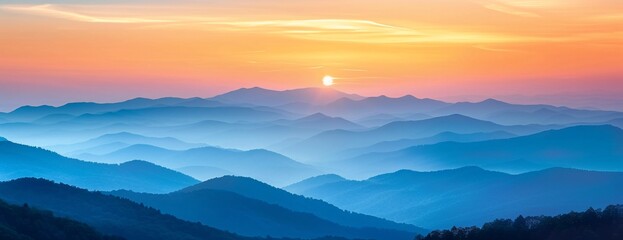 Wall Mural - Panoramic view of layered mountains under sunset, gradient of blue to orange hues in sky