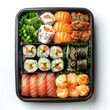 Take-away box with a variety of sushi, seafood, shrimps, and green vegetables. Asian takeout food in a black plastic container, isolated on white background. Top view.