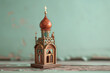 A miniature traditional Russian izba with carved wood details, on a wooden surface. The background is a pale mint green.