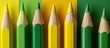 Vibrant row of assorted sharpened pencils on a vivid green background