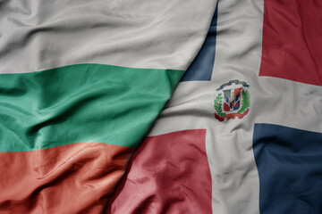 Wall Mural - big waving national colorful flag of dominican republic and national flag of bulgaria .
