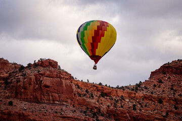 Wall Mural - hot air balloon floating over southern Utah desert and cloudy skies