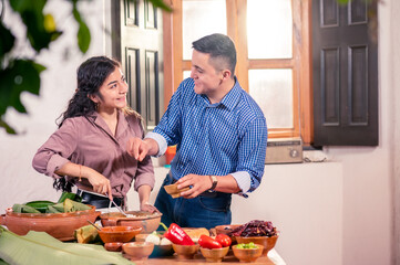 Wall Mural - Young Latin couple cooking Christmas dinner.