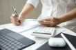 © littlepigpower - Woman using a calculator to calculate a credit card bill information at office