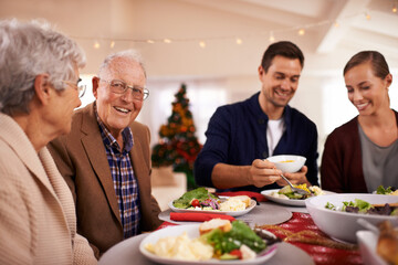 Wall Mural - Christmas, happy family and eating lunch in home, smile and bonding together at party. Xmas, food and senior parents at table for festive celebration, relax and people on holiday with salad for meal