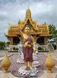 Fototapeta Londyn - Golden designed buddhist temple architecture pagoda and standing buddha statue at the Ancient City Siam Bangkok historical museum site.