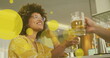 Image of spots over happy biracial woman with caucasian friend drinking beer