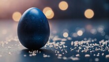 A Single Blue Egg Rests Delicately On A Smooth Black Surface, Evoking The Joy And Renewal Of Spring, The Excitement Of Easter Holidays, And The Perfection Of A Spherical Water Droplet Or Ball
