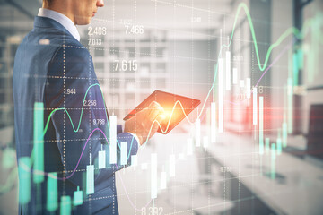 Wall Mural - Businessman hands using pad with growing forex chart on blurry office interior background. Financial investment and economy concept. Double exposure.