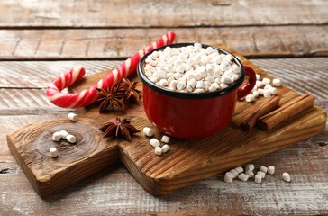 Sticker - Tasty hot chocolate with marshmallows and candy cane on wooden table