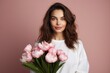 © Fotograf - A woman holding a bunch of pink flowers. Perfect for spring-themed designs