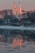 The pink light of the morning sun on the snow-white walls of St. Sophia Cathedral and in their reflection in the waters of the Western Dvina. Polotsk, Belarus