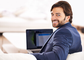 Wall Mural - Happy, portrait and businessman with remote work on sofa with laptop in home or living room. Entrepreneur, smile and working in lounge with computer for online research, report or journalist writing