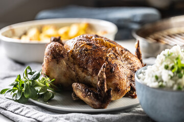 Wall Mural - A whole roasted chicken on the table together with jasmine rice and baked potatoes.