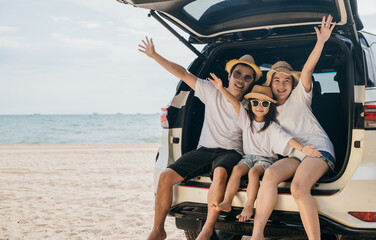 Wall Mural - Family Day. Happy people having fun in summer vacation on beach, Family traveling in holiday at sea beach, Dad, mom and children daughter enjoying road trip sitting on family back car raise hand up