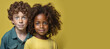 © Natalia Maliseva - Portrait of a red-haired curly boy and an African-American smiling girl on a yellow background copy space, AI generated