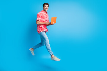 Aufkleber - Full body photo of successful guy wear stylish shirt jeans trousers run empty space with laptop in hands isolated on blue color background