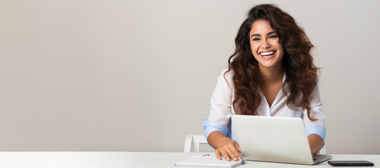 Online courses, distant education, work banner. Smiling beautiful young brunette woman 20s working on laptop pc computer at a desk on light grey background. Young smiling business woman. Copy space