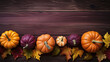 A group of pumpkins with dried autumn leaves and twigs, on a dark maroon color wood boards