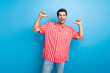 Photo of optimistic confident perky man with bristle dressed striped shirt indicating at himself isolated on blue color background