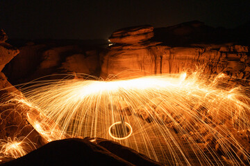 Abstract background of steel wool fireworks on Hat Chom Dao at after twilight blue hour, Showers of glowing sparks from spinning steel wool, Na Tan, Na Tan District, Ubon Ratchathani, Thailand