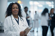© GustavsMD - Mature Black Female Doctor with Clipboard. Accomplished black female doctor in white coat, medical team behind.