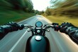A modern biker driving down the road, blurred, low-angle, glossy finish.