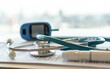 Medical equipment, diabetes checking blood sugar level test, glucometer, stethoscope and clipboard on doctor's work desk background with patient health record exam or diagnosis for health care.