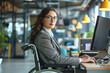 a businesswoman with disability sitting in wheelchair working at office