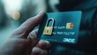 © Oulaphone - Security technology concept. Man hand holding credit or debit card with padlock, protection of financial transactions.