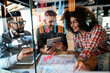 © Nedrofly - Three People Sitting at a Table Looking at a Tablet. Generative AI.