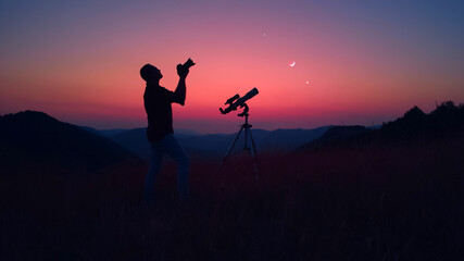 Wall Mural - astronomer with a camera photographing night skies.