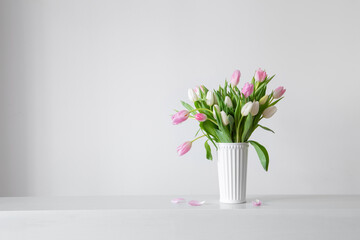 Wall Mural - white and pink   tulips in white vase on background wall