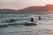 People go surfing in the waves of the Atlantic Ocean at Geriba beach on sunset in Buzios, Rio de Janeiro, Brazil