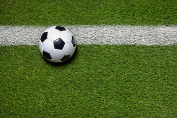 Wall Mural - Soccer ball on grass field with stripe overhead view