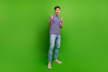 Sticker - Full size photo of handsome positive impressed guy dressed denim pants striped shirt indicating at you isolated on green color background