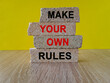 Make your own rules symbol. Concept words Make your own rules on brick blocks. Beautiful wooden table, yellow background. Business motivational make your own rules concept. Copy space