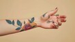 © Ziyan Yang - The trend of tattoos on a girl s hand reflects the spirit of freedom, rebellion and uniqueness. Banner of a delicate tattoo on a beige background.