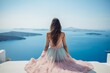 Woman in stylish summer dress sitting on white surface with beautiful blue sea background