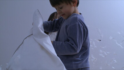 Wall Mural - Kids in the midst of a pillow fight in bed with feathers flying everywhere captured with a high speed camera at 1000 fps in speed ramp