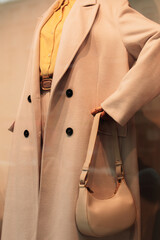 Sticker - Details of a seasonal beige coat, a bright yellow shirt and a small handbag. Casual women's fashion cloth and accessories