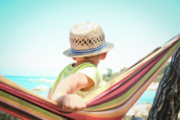 happy child by the sea on hammock in greece background