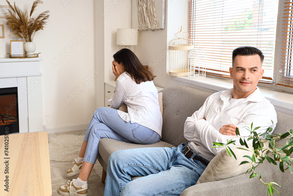 Offended young couple after quarrel sitting at home